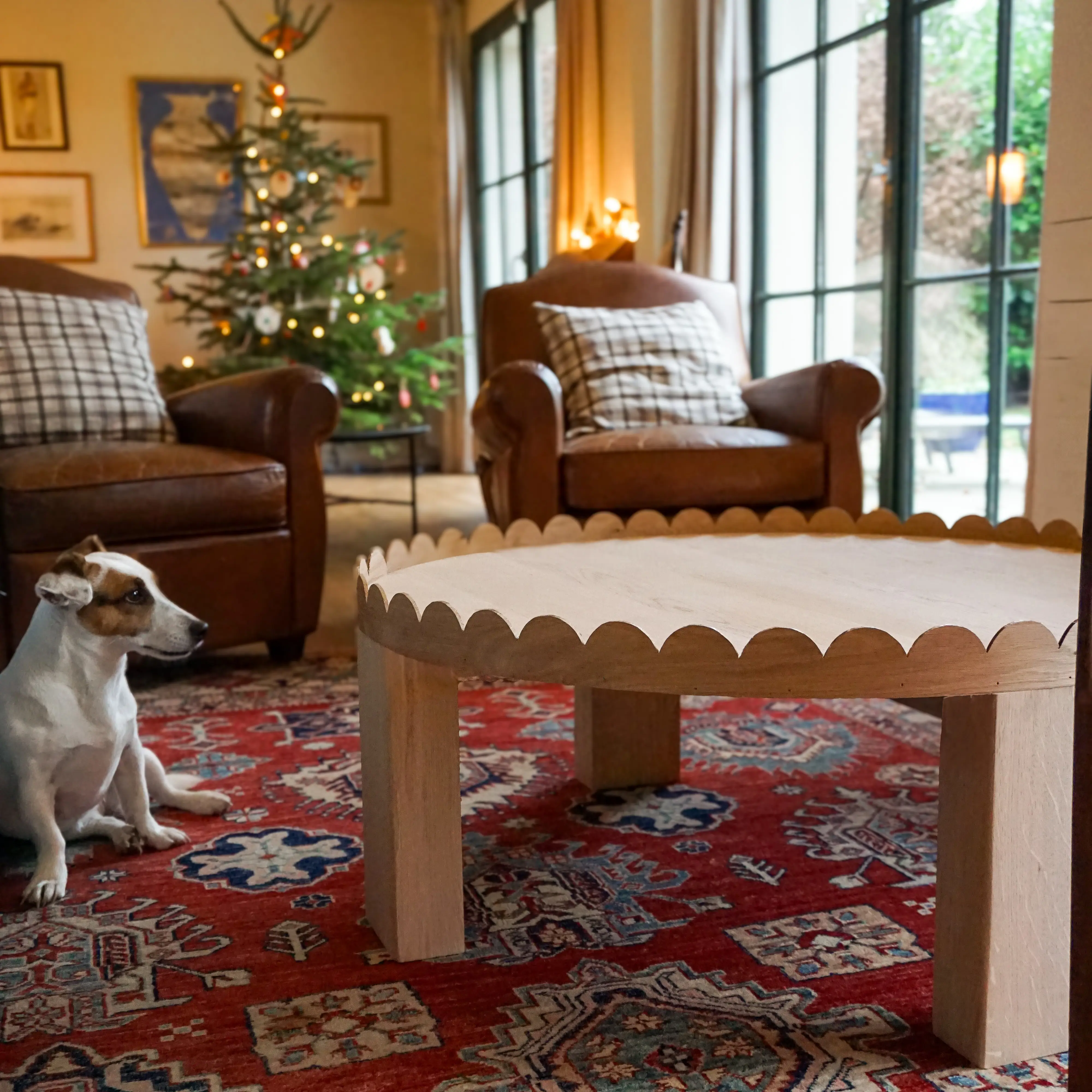 Table basse ronde en chêne clair massif avec des motifs festonnés.