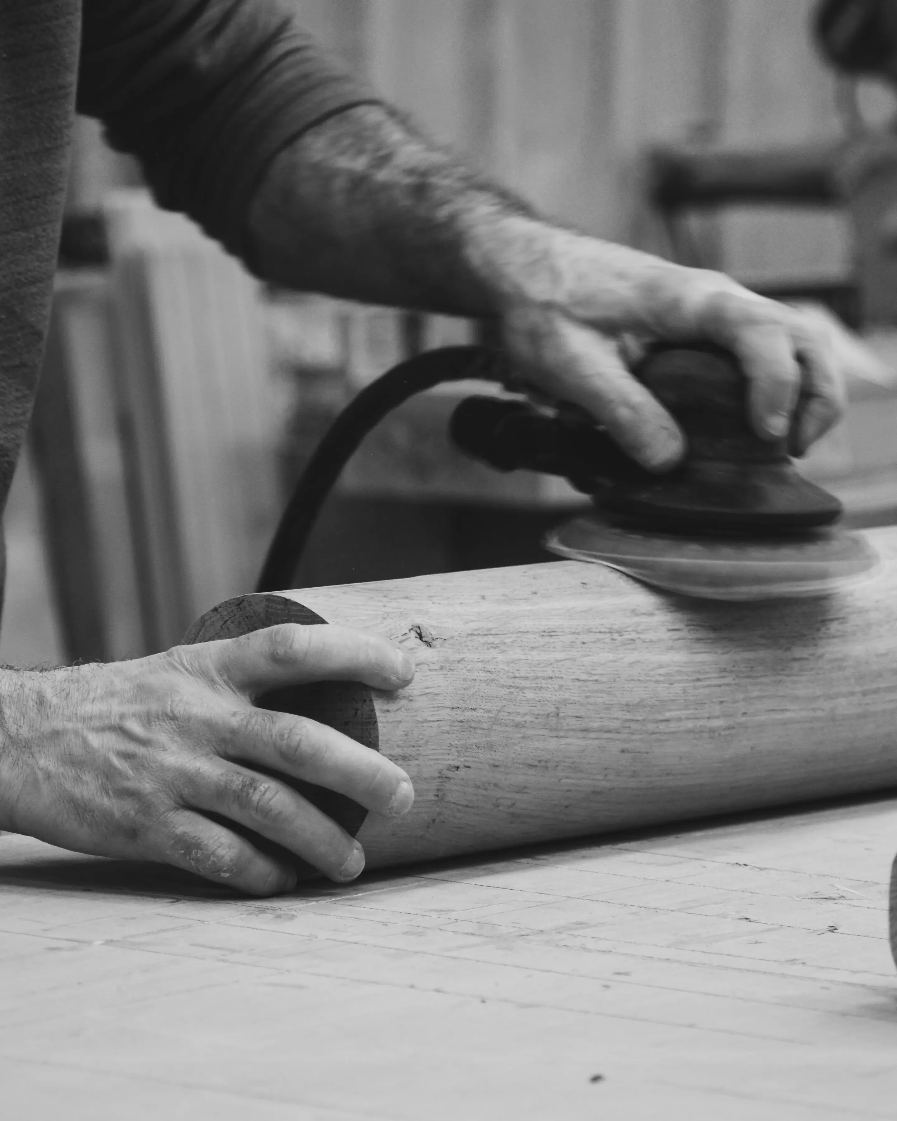 Ponçage d’un pied de table en bois de forme arrondie. Création d’une table en chêne massif sur-mesure. Fabrication haut de gamme éternel sur-mesure et éthique Maison Charlet.