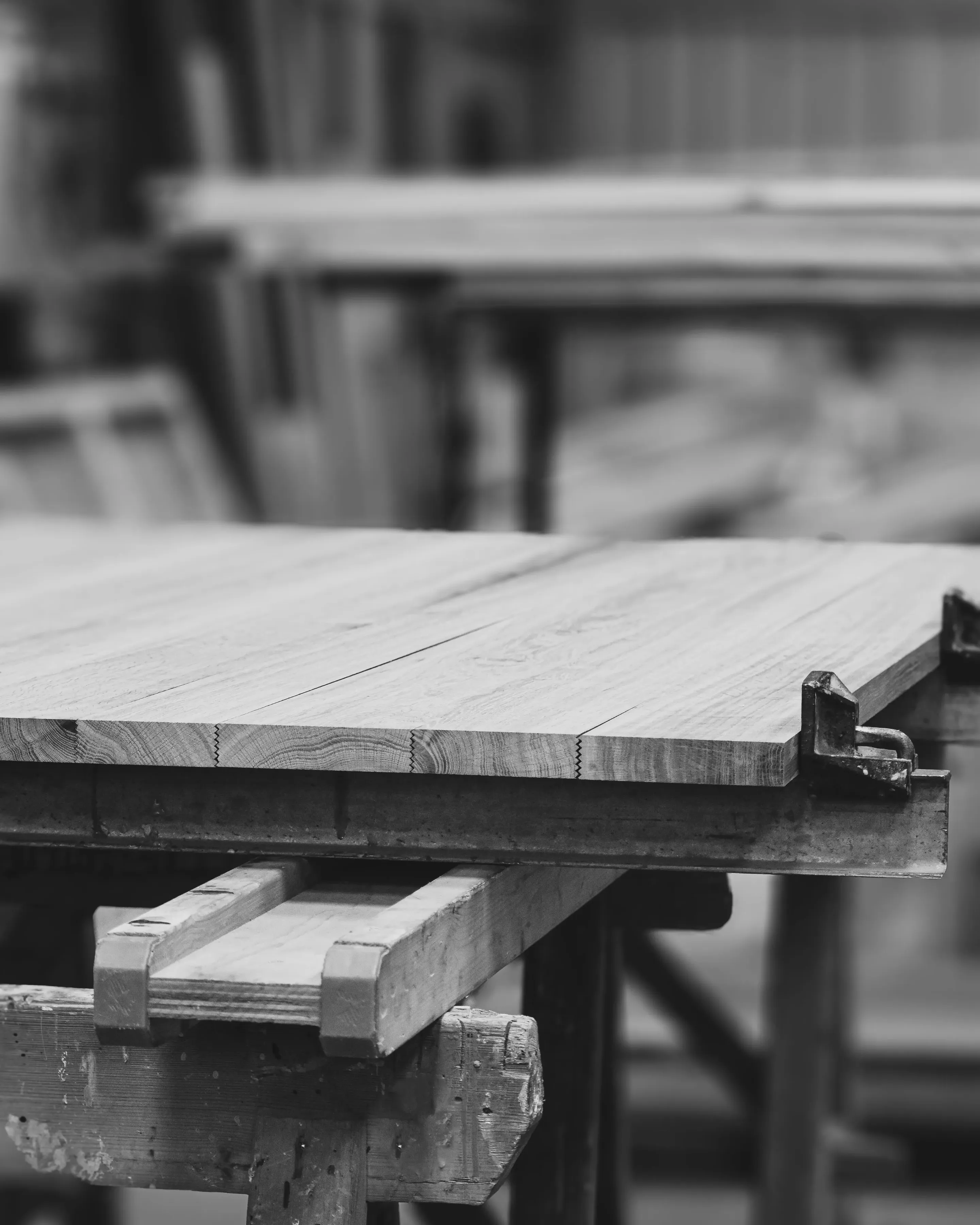 Fabrication table en bois sur-mesure à partir de bois massif dans atelier menuiserie. Plateau rectangulaire avec bords droits. Création haut de gamme éternel sur-mesure et éthique Maison Charlet.